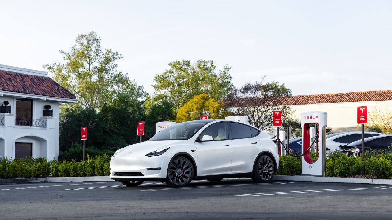 White Tesla Model Y at Supercharger