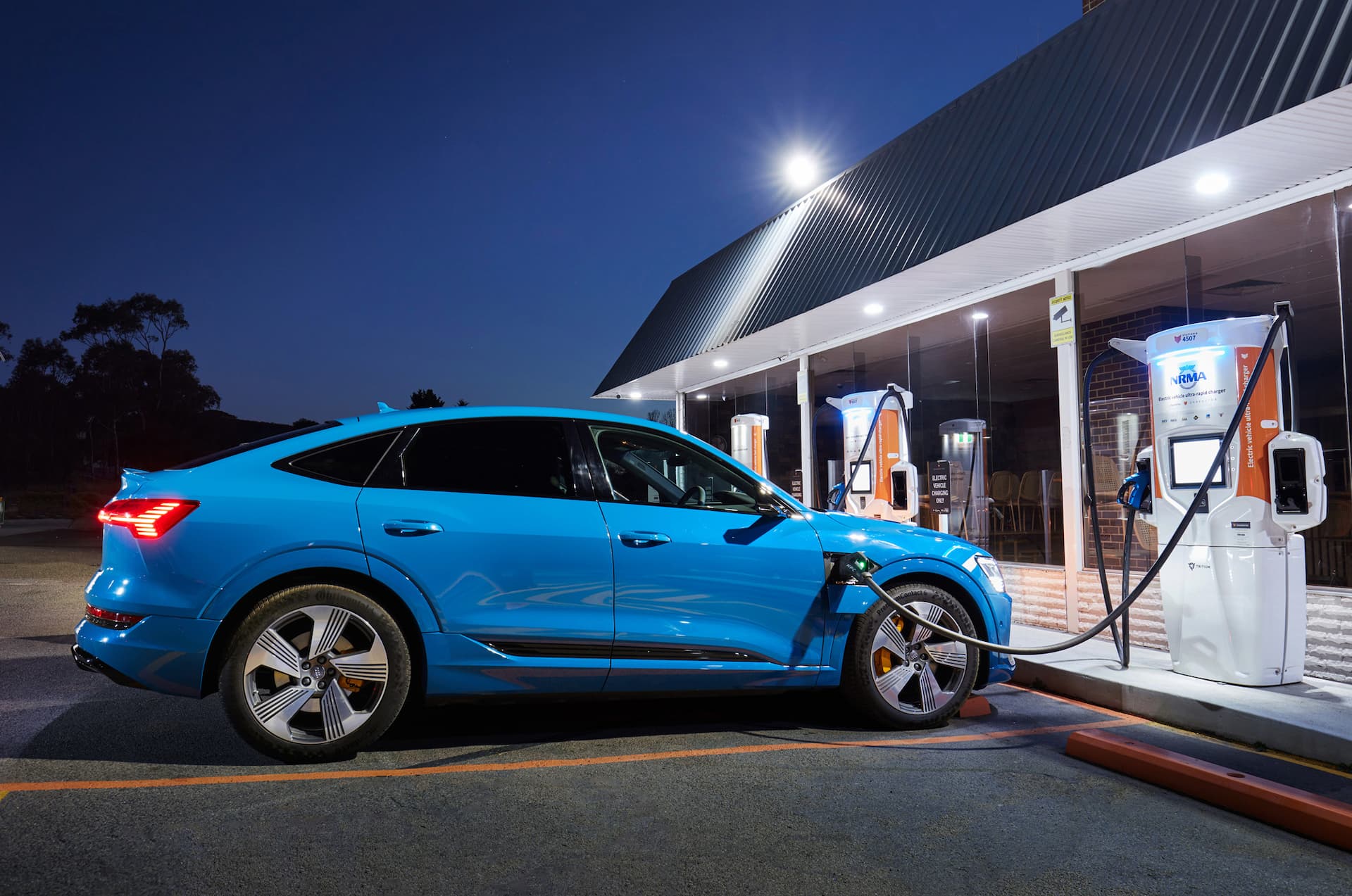 Blue Audi e-Tron Sportback charging at NRMA Chargefox DC ultra rapid charger night