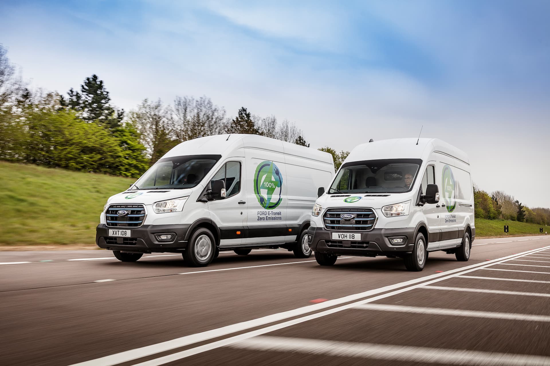 Two white Ford e-Transits driving
