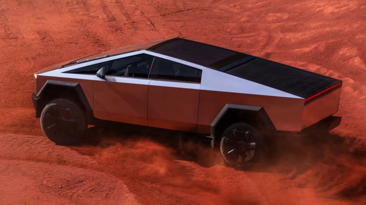 Tesla Cybertruck driving on red-orange desert sand