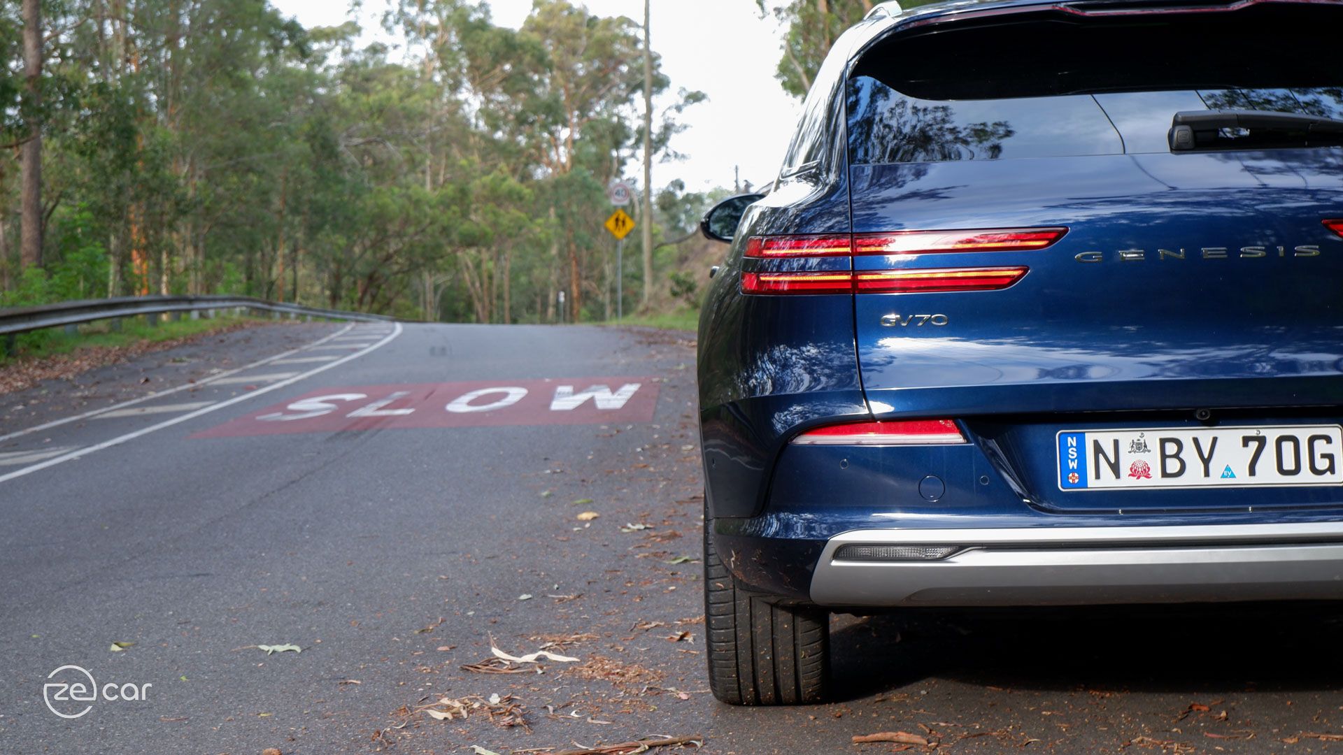 Genesis Electrified GV70 rear in front of 'slow' on road