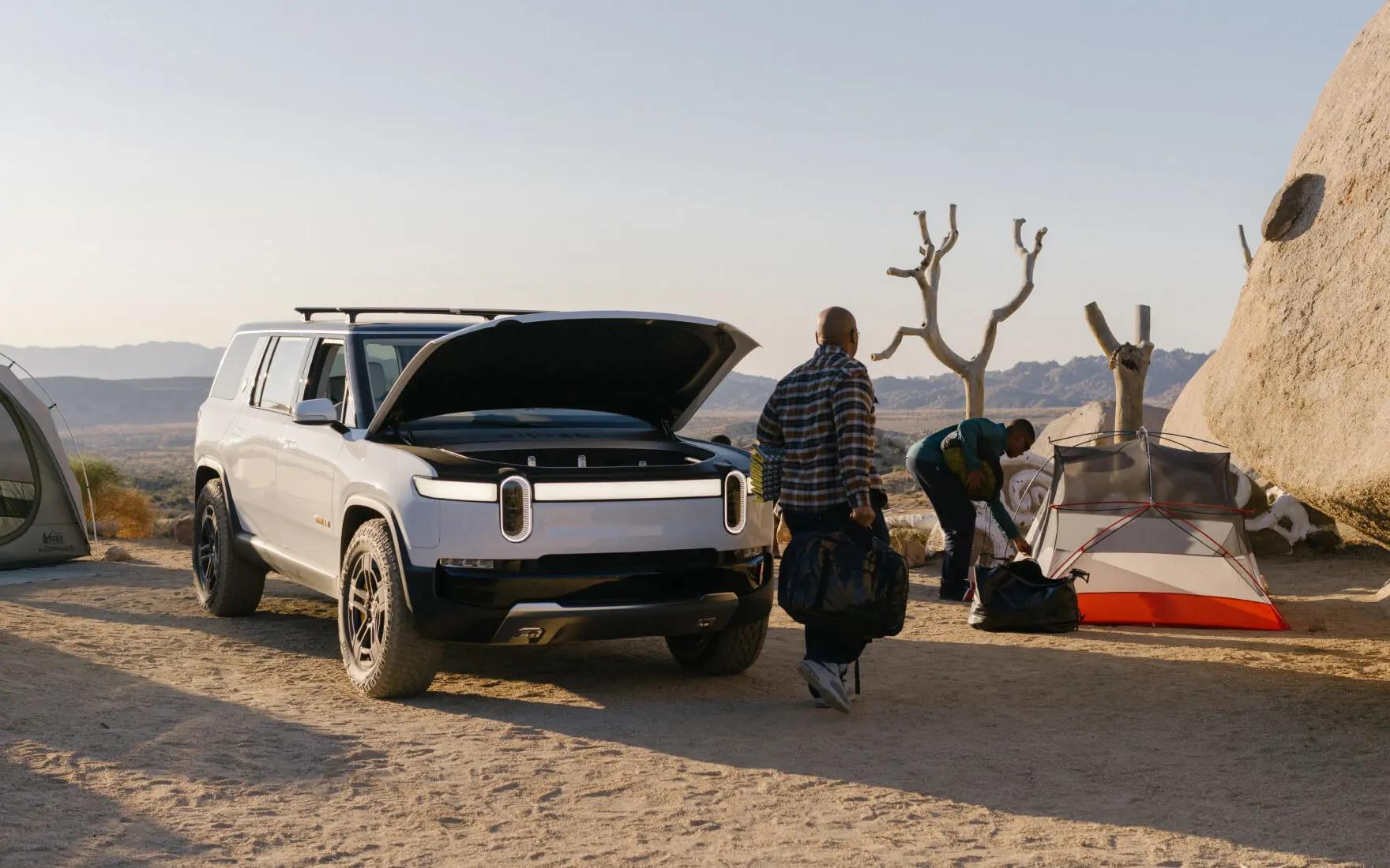 White Rivian R1S with frunk open in camp