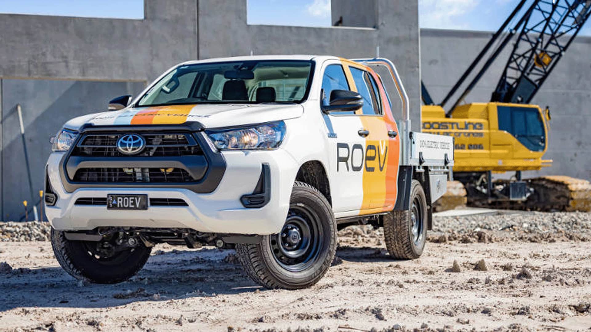 White ROEV Toyota Hilux in front of yellow crane at a construction site