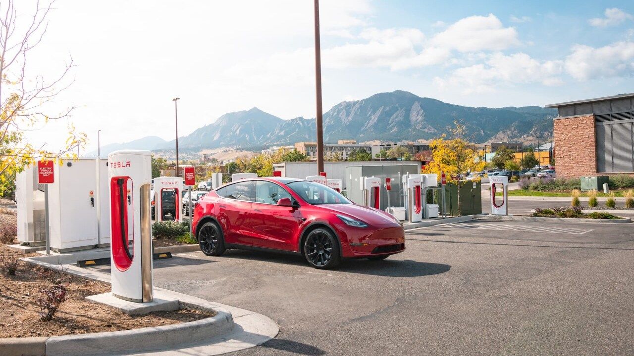 Red Tesla Model Y charging at Tesla Supercharger