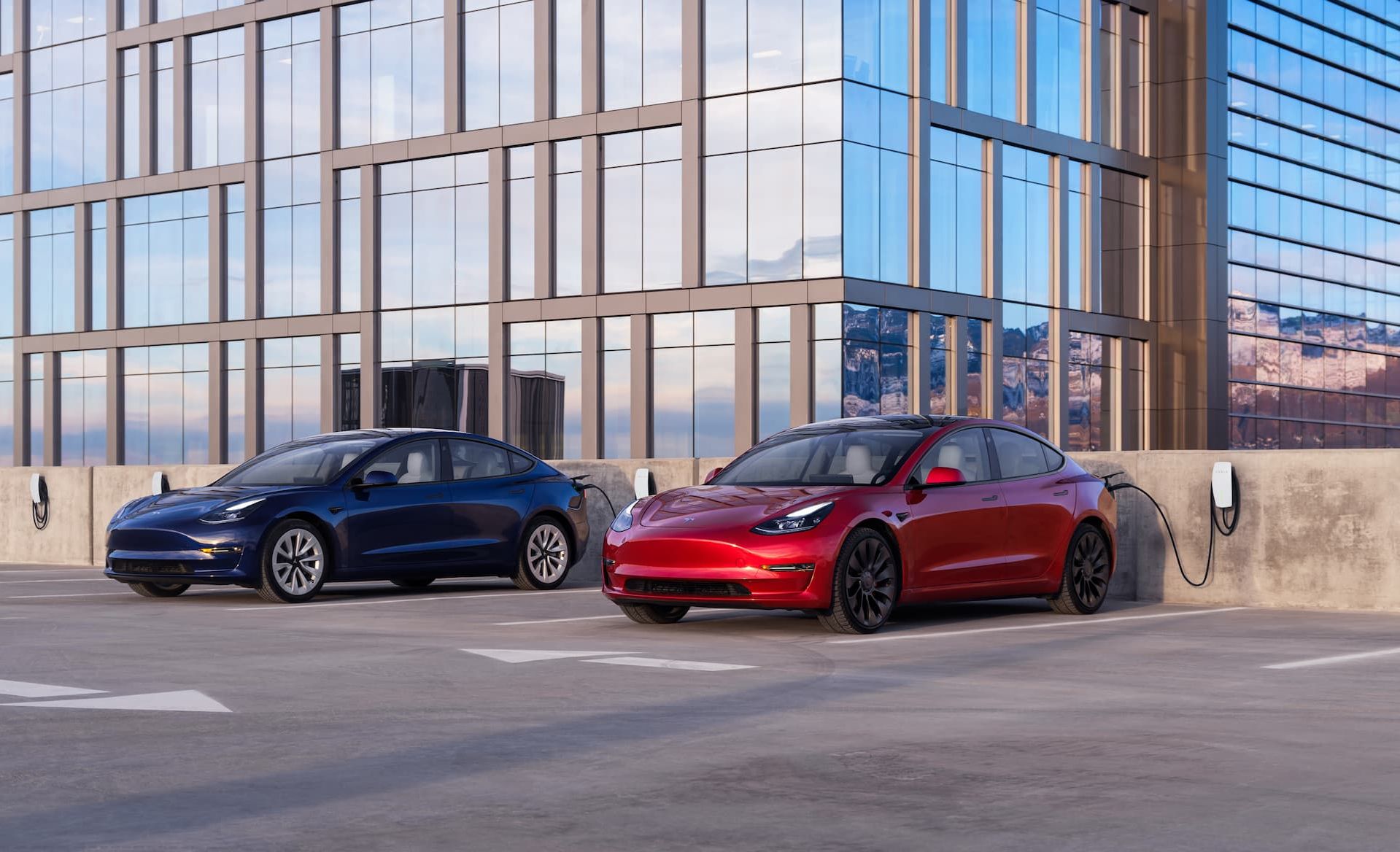 Blue and red Tesla Model 3 charging