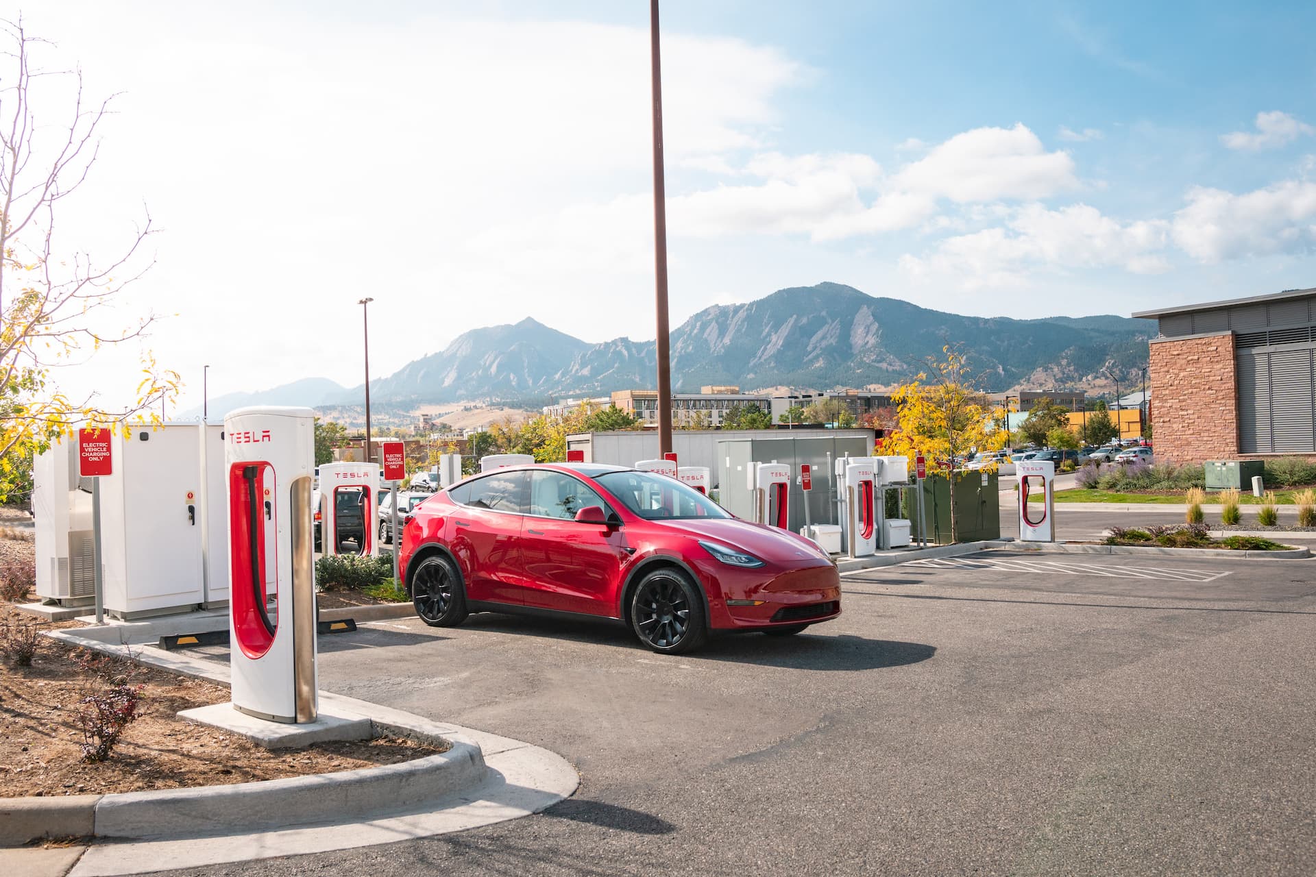 Red Tesla Model Y at Supercharging station