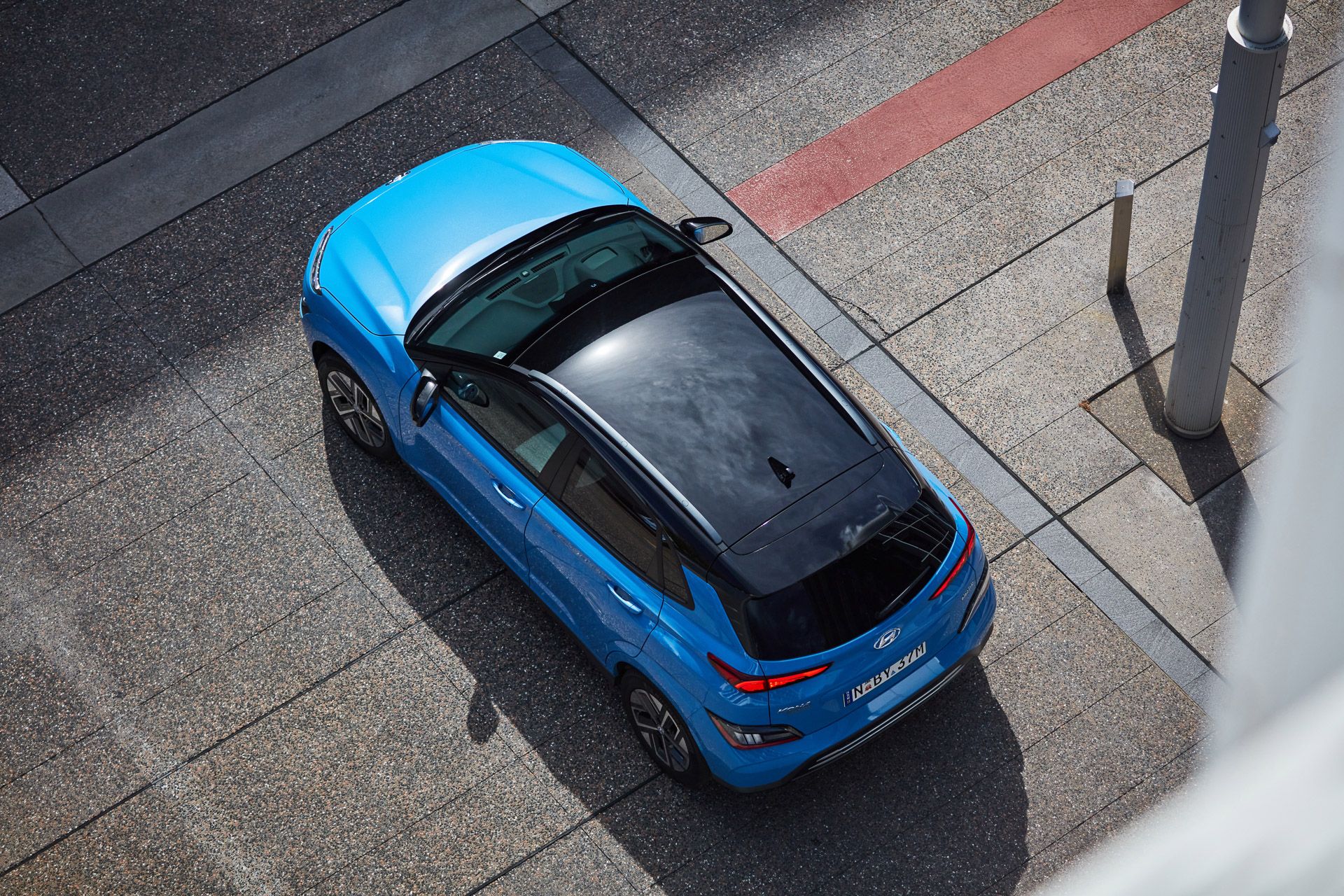 Blue Hyundai Kona Electric with black roof top-down view