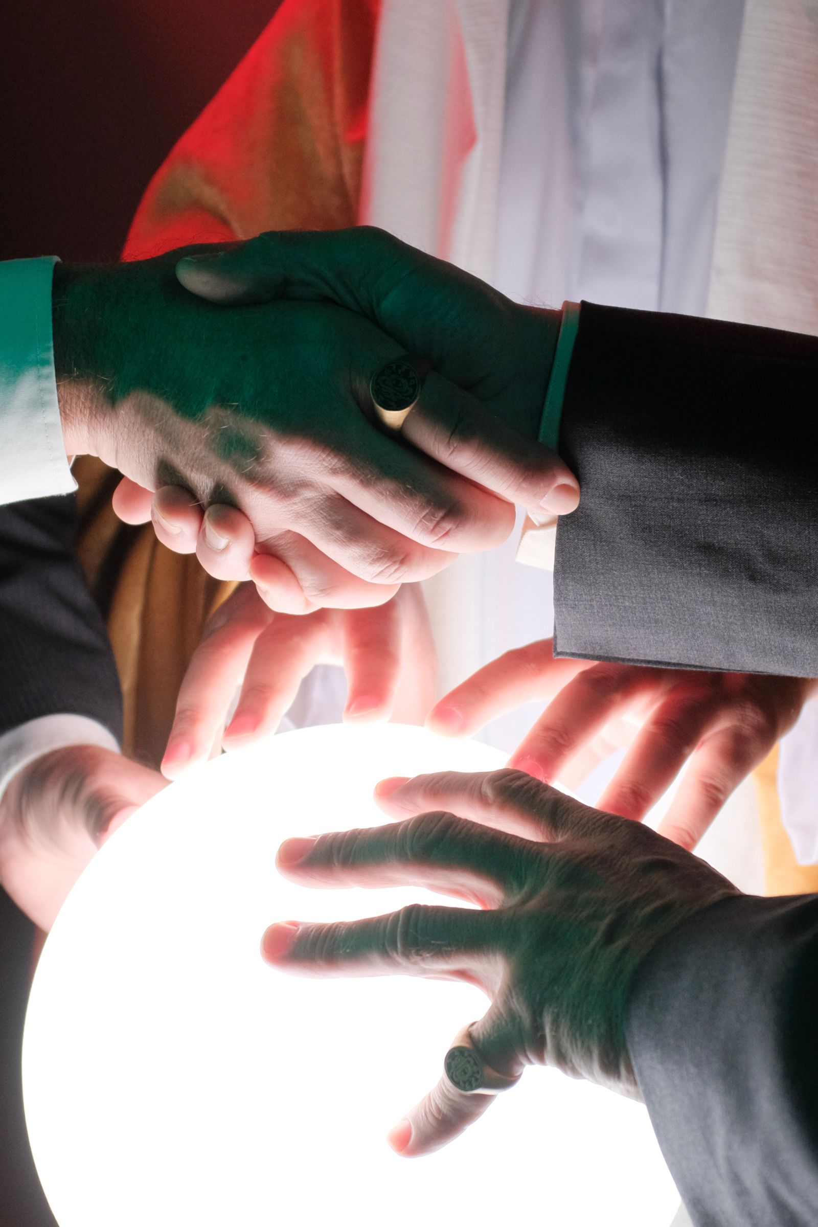 2 men shaking hands with a large signet ring visible