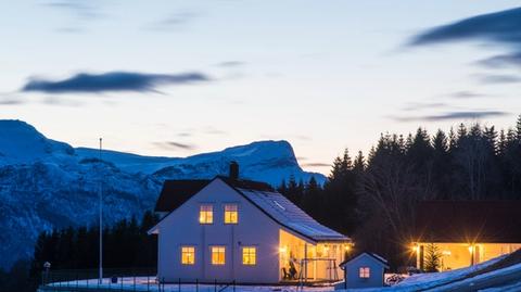 Eit godt belyst hus i snødekt landskap