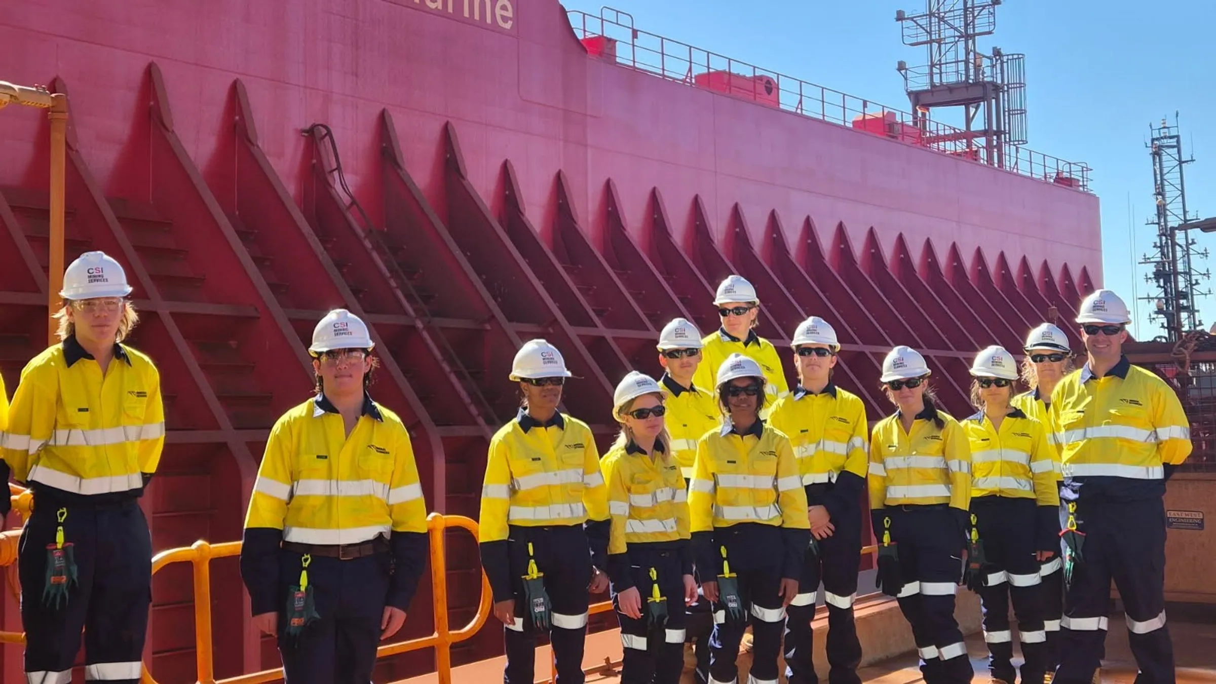 students standing in front of a minres marine ship