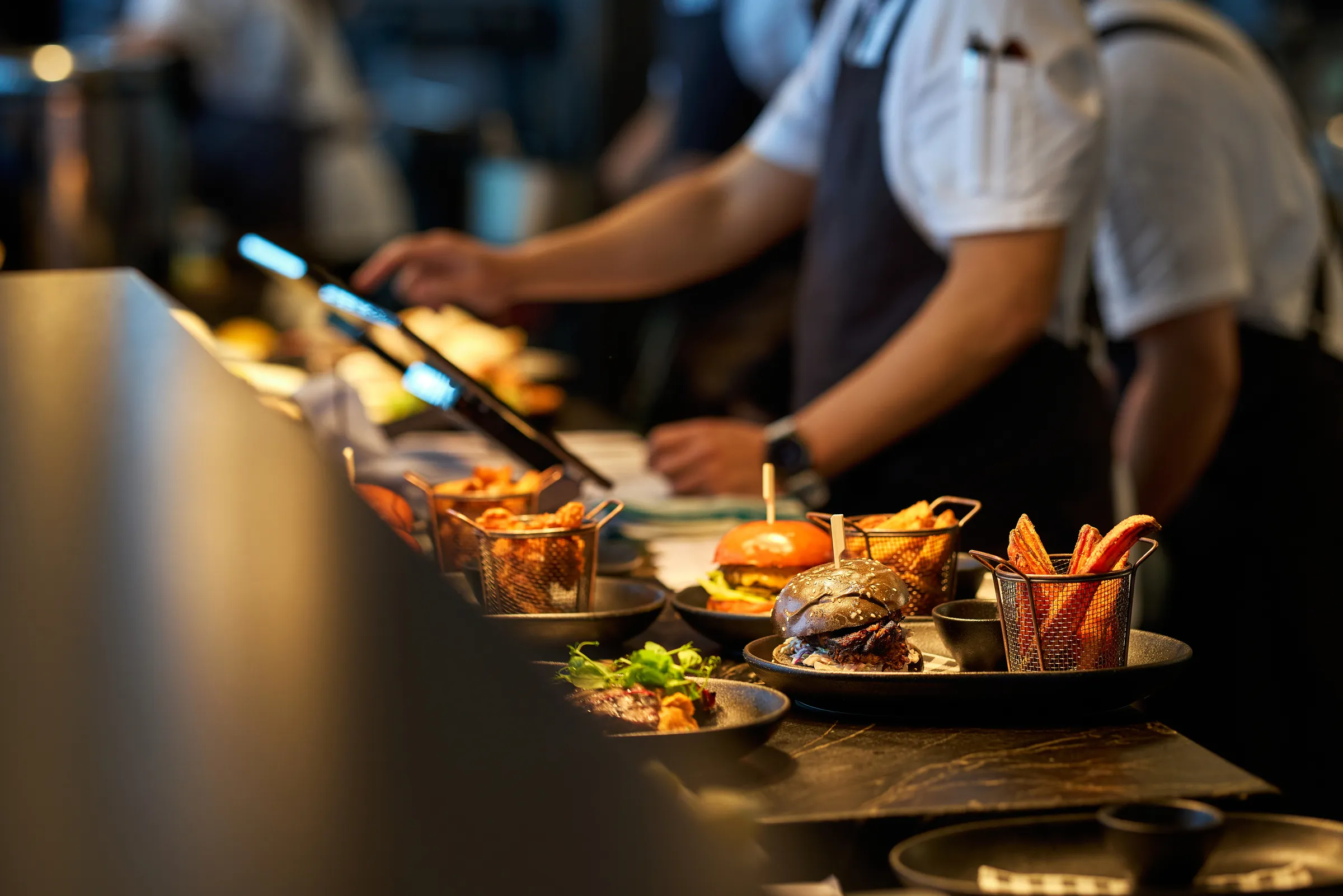 Food sitting on a bench with people waiting to serve