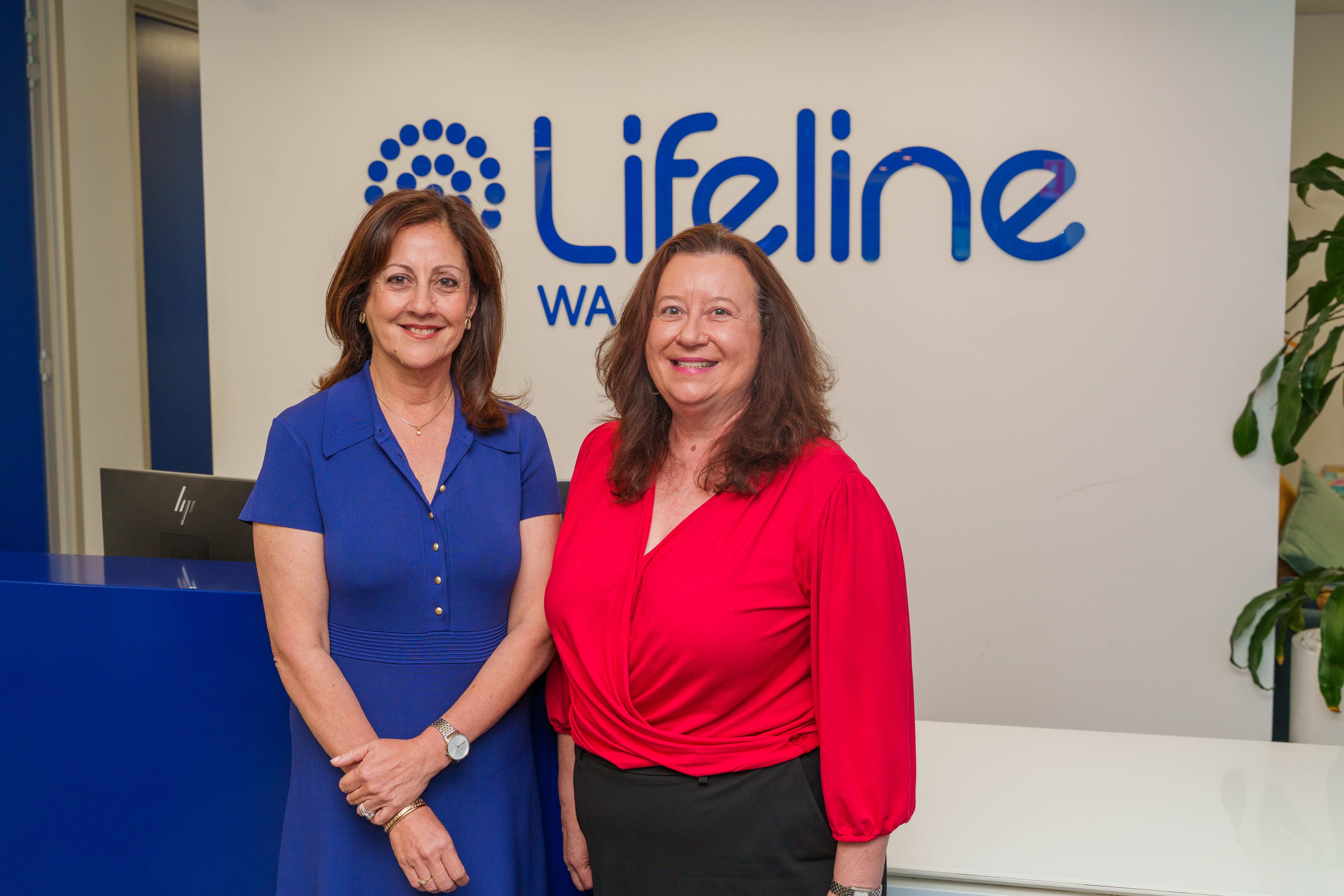 Image of two women infront of liefeline sign/office