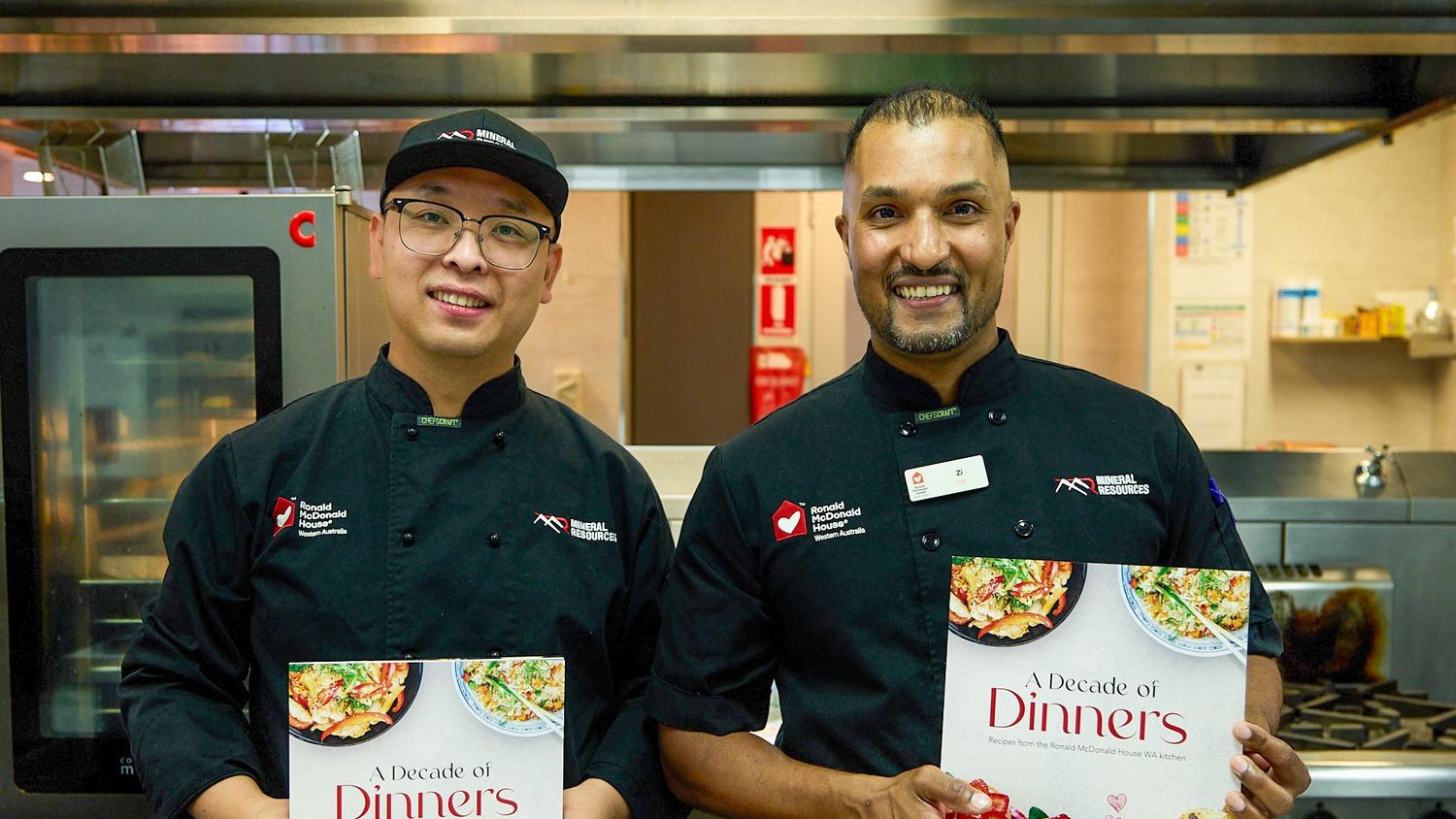 Two chefs holding cook books