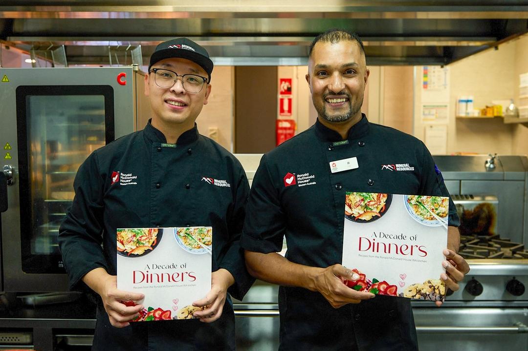 Two chefs holding cook books