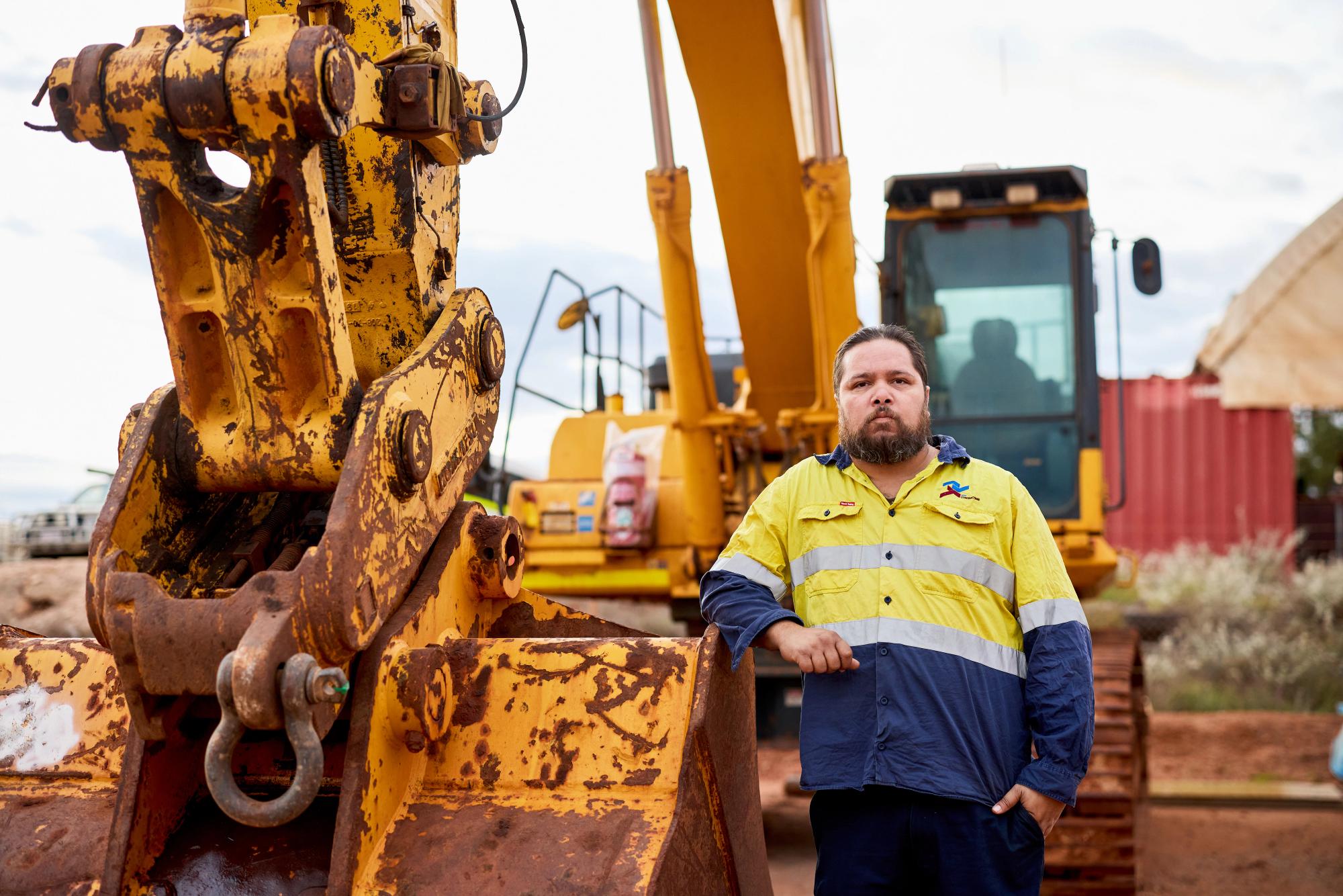 Man in high vis standing with machinery