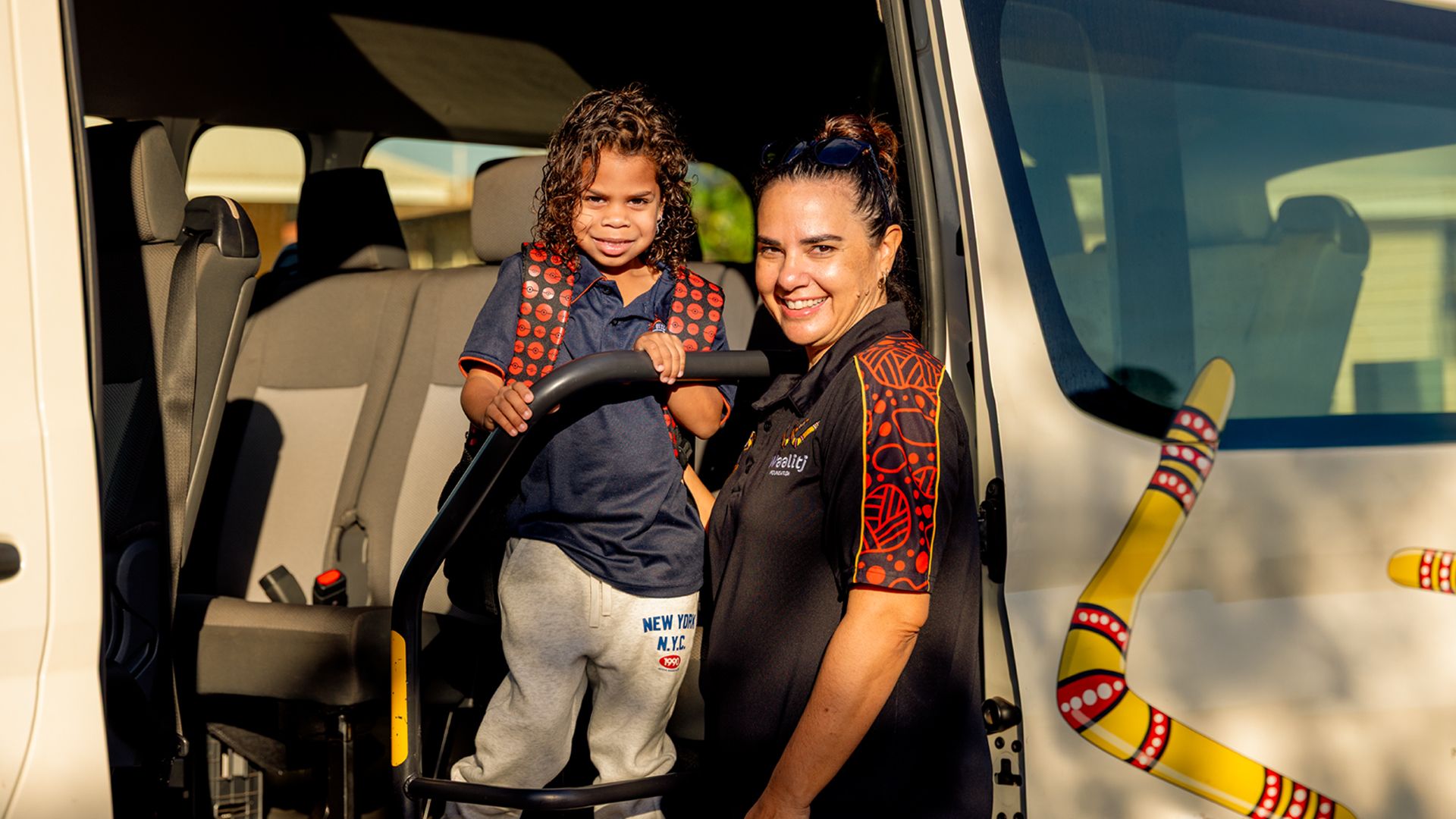 Women and child standing in a car