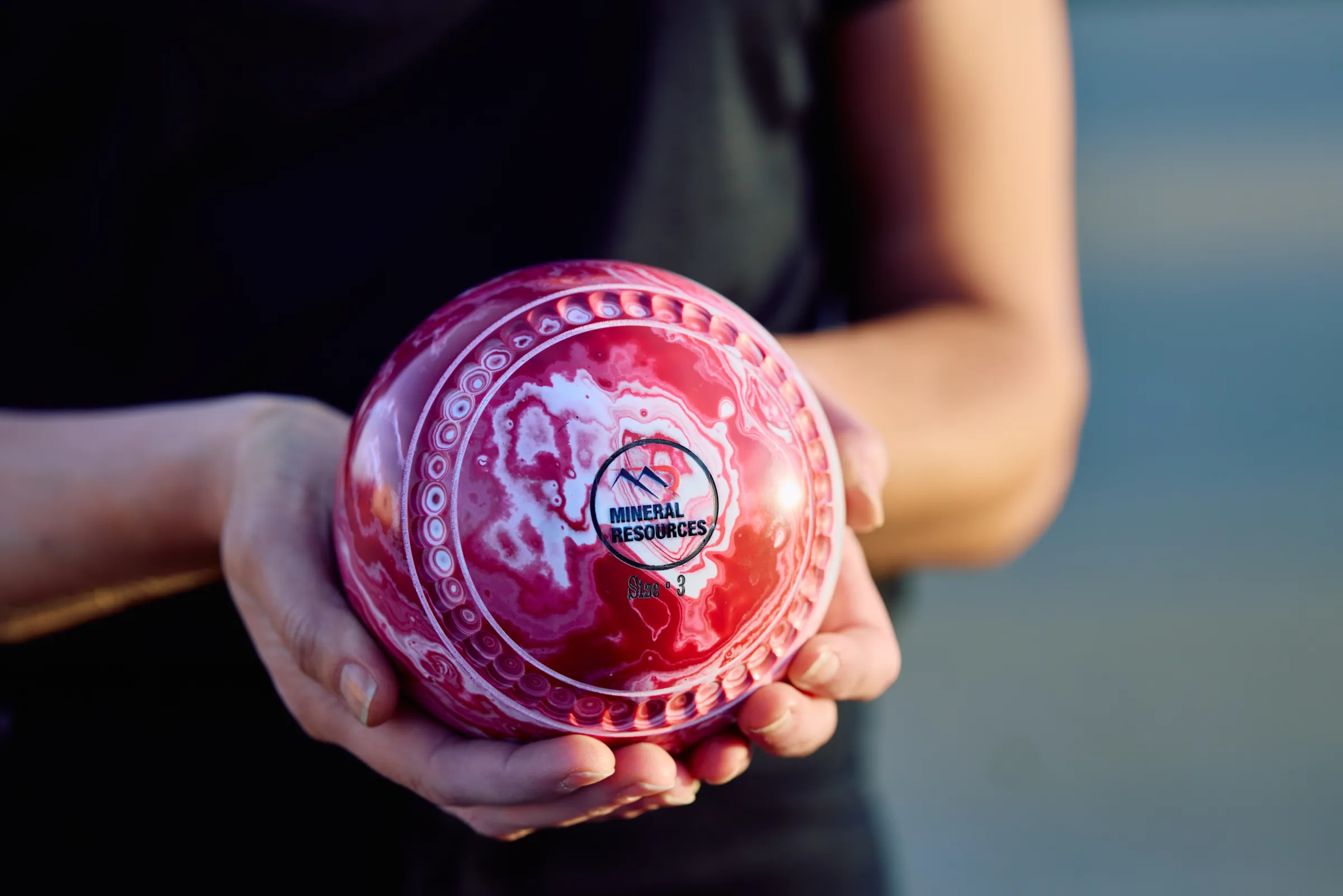 a persons hands holding a MinRes lawn bowl