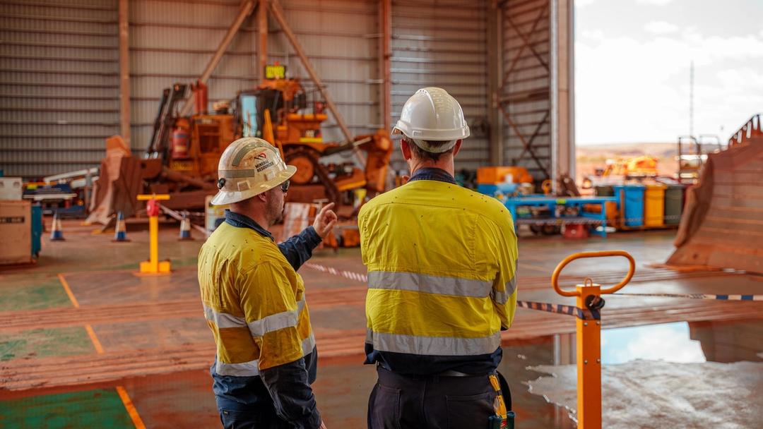 People standing in a workshop in high vis