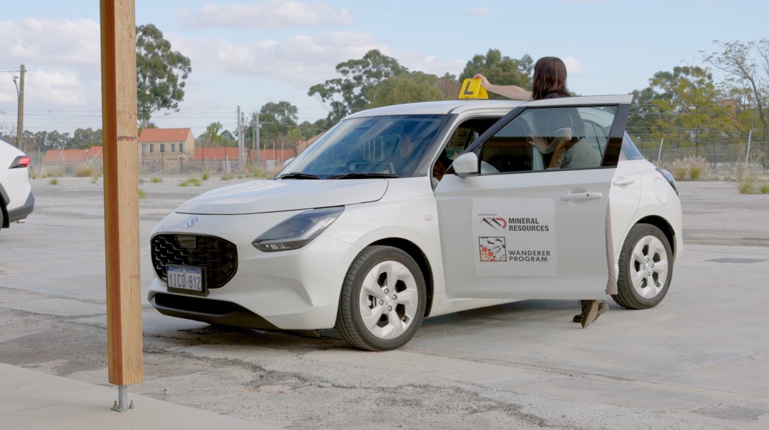 Person placing L plates on a car