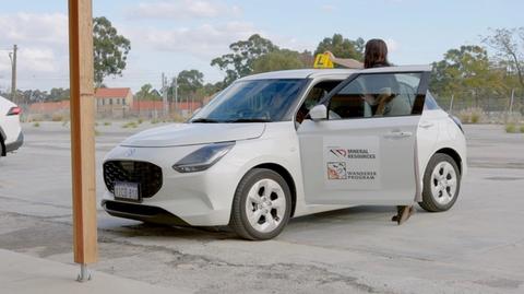 Person placing L plates on a car