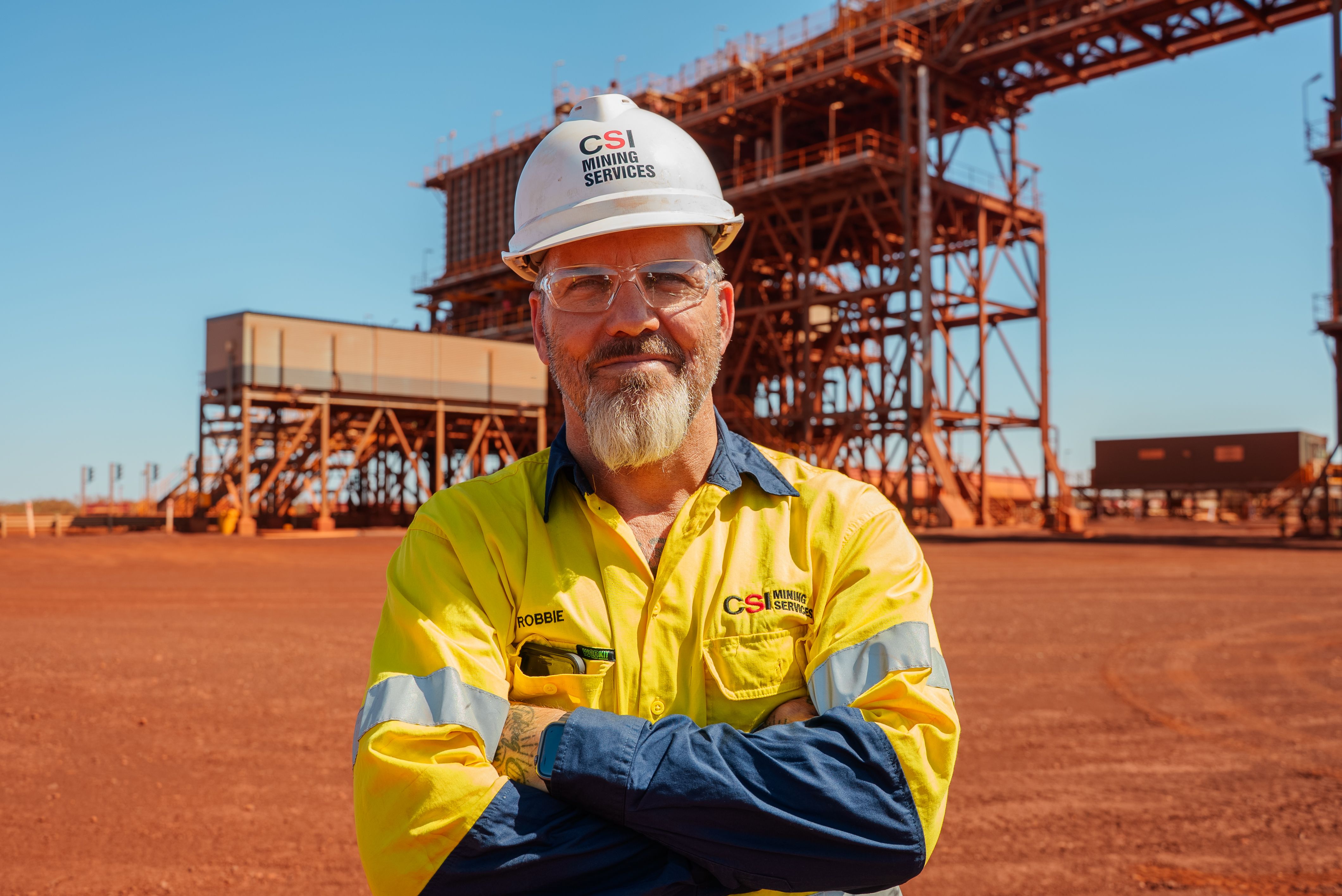 Man in high vis standing with his arms crossed