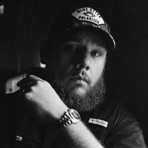A black and white photograph of Luke Combs in blue otter polarized camo cap and black columbia shirt.