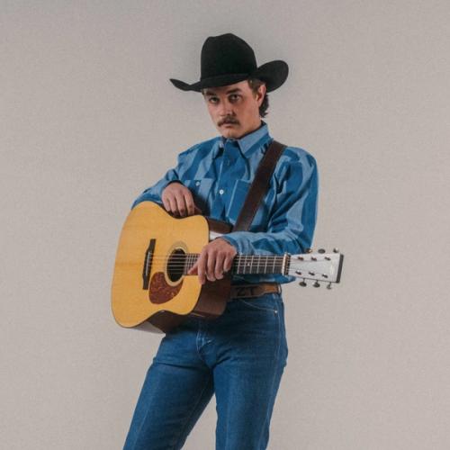 Zach Top wearing a cowboy hat and holding a guitar