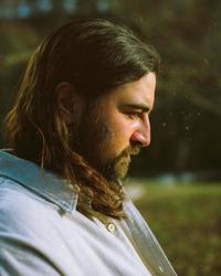 Noah Kahan looking reflective