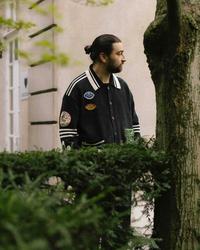 Noah Kahan behind a hedge