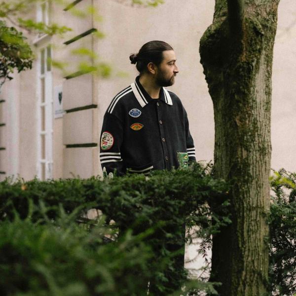 Noah Kahan behind a hedge