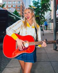 Elizabeth Nichols posing with a guitar in New York