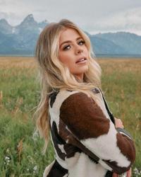 Anne Wilson in a field with mountains in the background