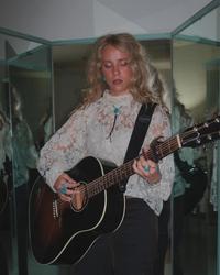 Avery Anna playing the guitar backstage