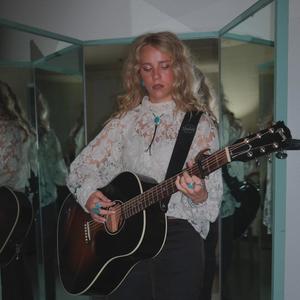 Avery Anna playing the guitar backstage