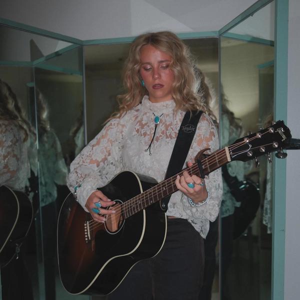 Avery Anna playing the guitar backstage