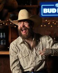 Post Malone laughing in a cowboy hat