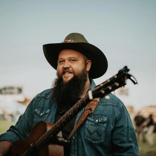 Larry Fleet smiling while wearing a hat