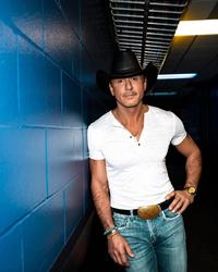 Tim McGraw leaning against a blue wall