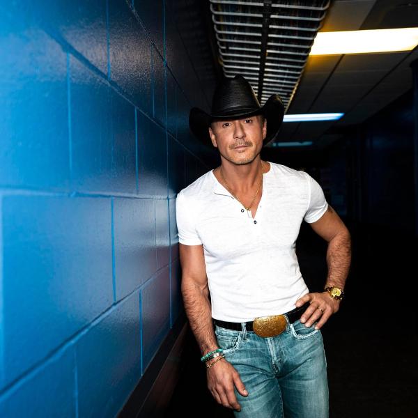 Tim McGraw leaning against a blue wall
