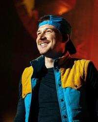 Morgan Wallen in a blue backwards-turned hat on-stage. 
