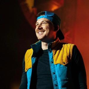 Morgan Wallen in a blue backwards-turned hat on-stage. 