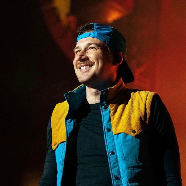 Morgan Wallen in a blue backwards-turned hat on-stage.