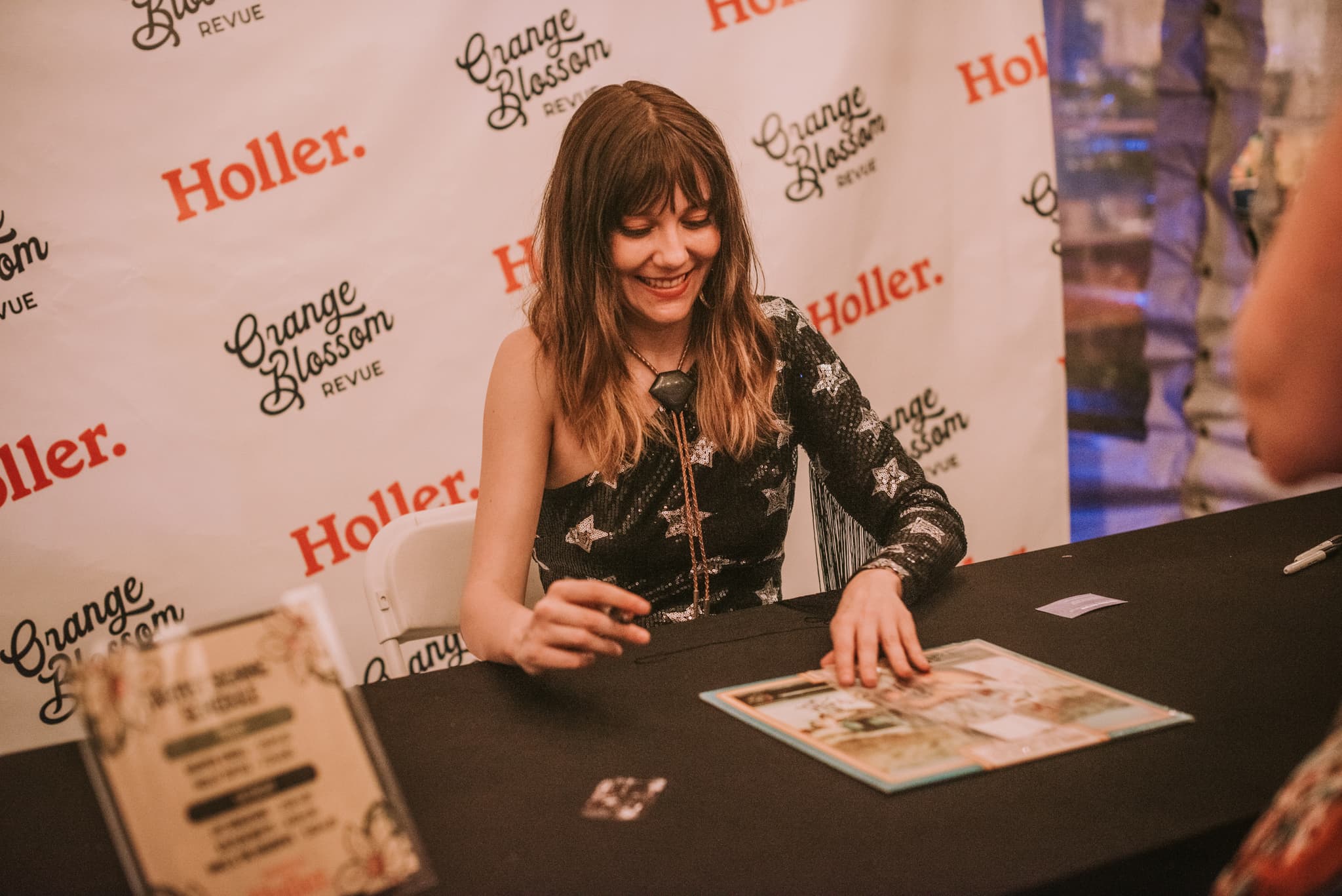 Molly Tuttle signing vinyl at the Holler Signing Tent at Orange Blossom Revue