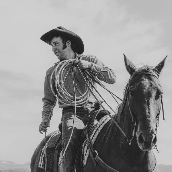 Luke Bell riding a horse with rope in black and white, taken by Mike Vanata.