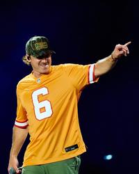 Morgan Wallen performing live in an orange jersey