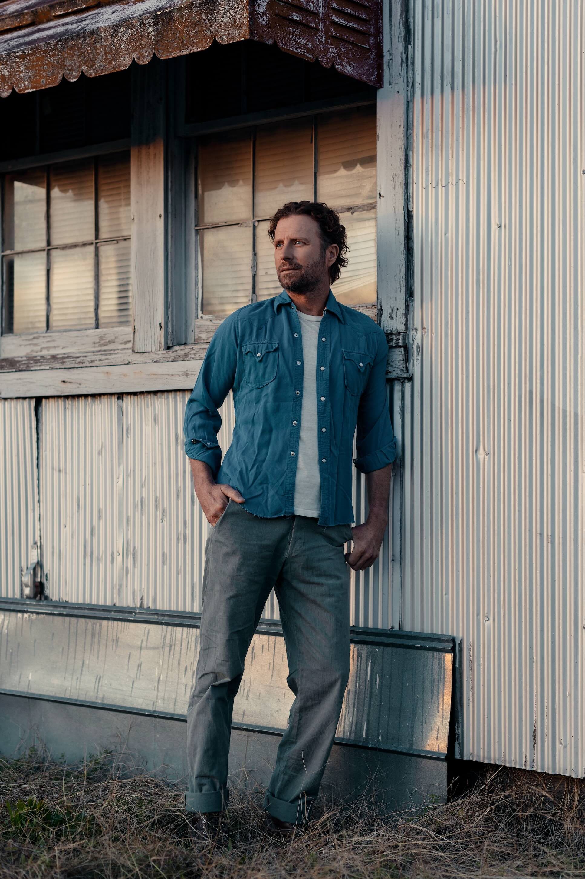 Dierks Bentley standing against a barn