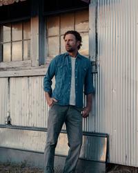 Dierks Bentley standing against a barn