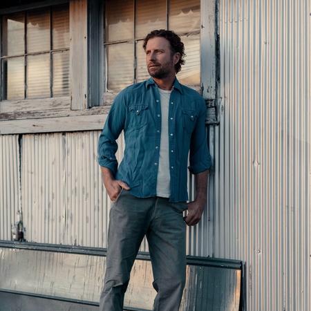 Dierks Bentley standing against a barn