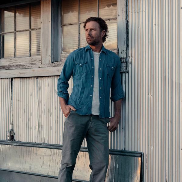 Dierks Bentley standing against a barn
