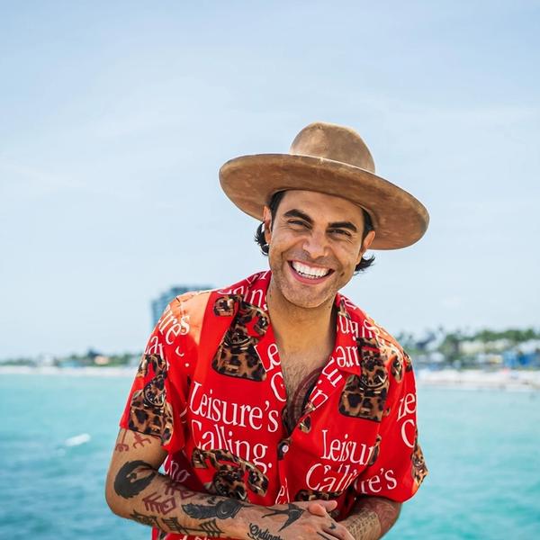 Niko Moon smiling in front of the ocean